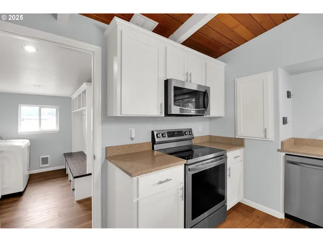 a kitchen with stainless steel appliances a stove a sink a microwave and cabinets