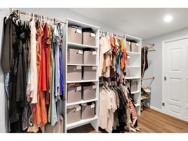 a view of walk in closet with clothes and shoes