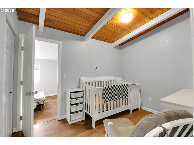 a view of a bedroom with furniture and wooden floor