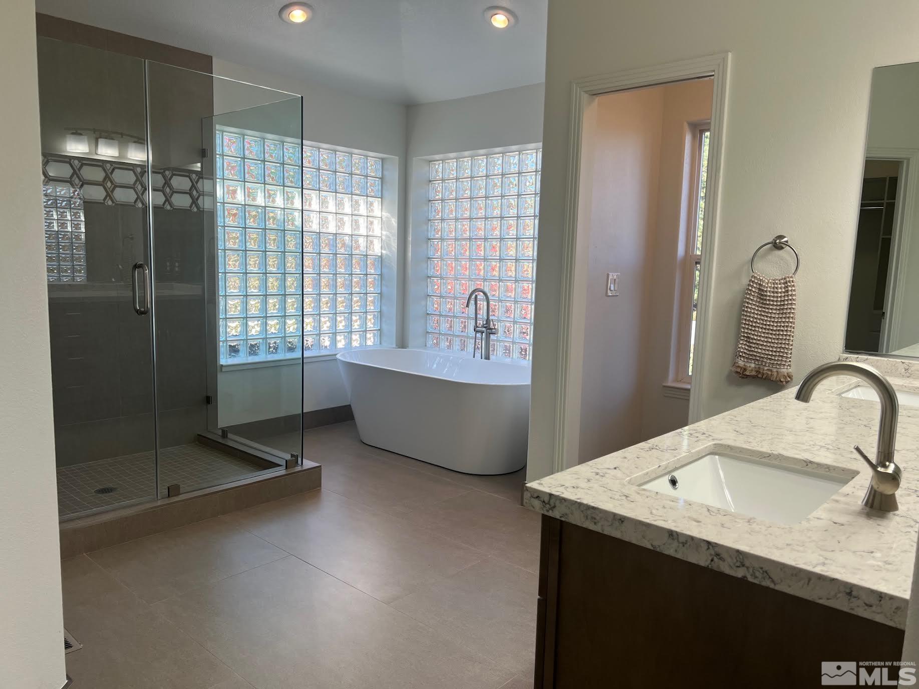 14230 Prairie Flower Court Reno, NV 89511 - Photo 16 of 39 a bathroom with a tub sink and mirror
