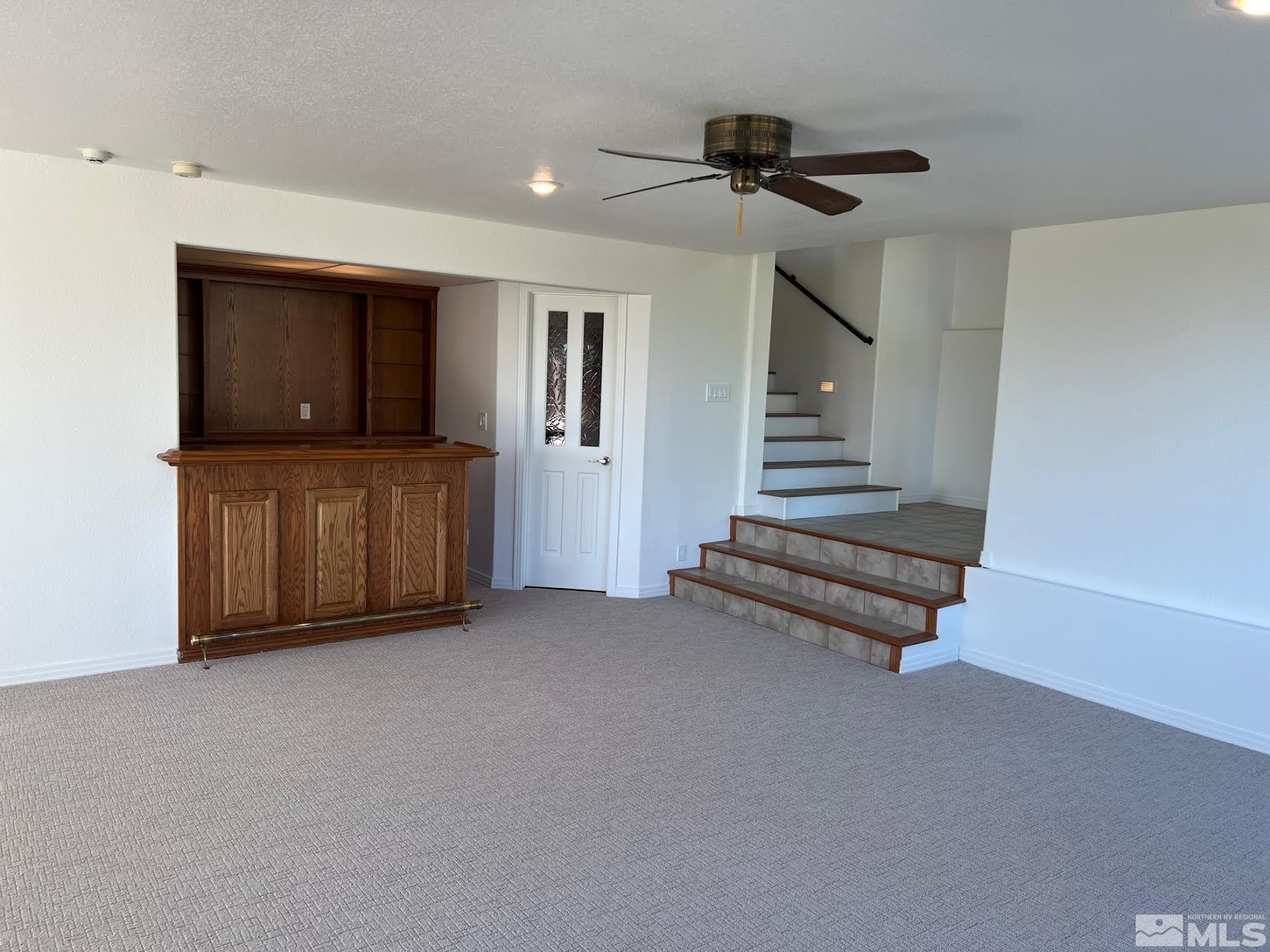 14230 Prairie Flower Court Reno, NV 89511 - Photo 26 of 39 a view of an empty room with stairs and a ceiling fan