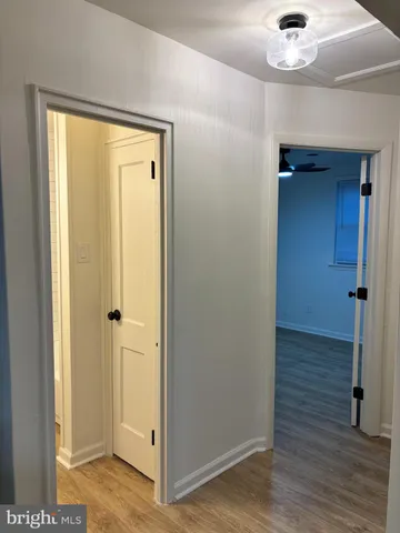 a view of a hallway with wooden floor and a chandelier
