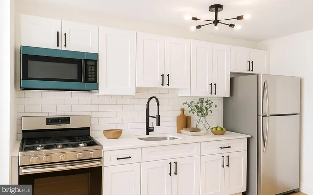 a kitchen with appliances a sink cabinets and a window