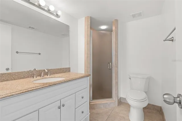 a bathroom with a granite countertop toilet sink and mirror