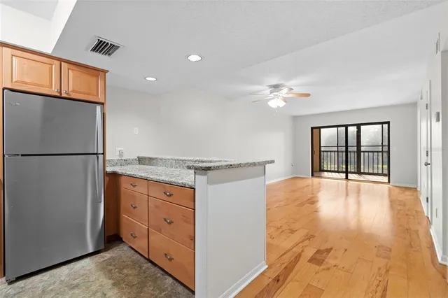 a view of an empty room with window and refrigerator