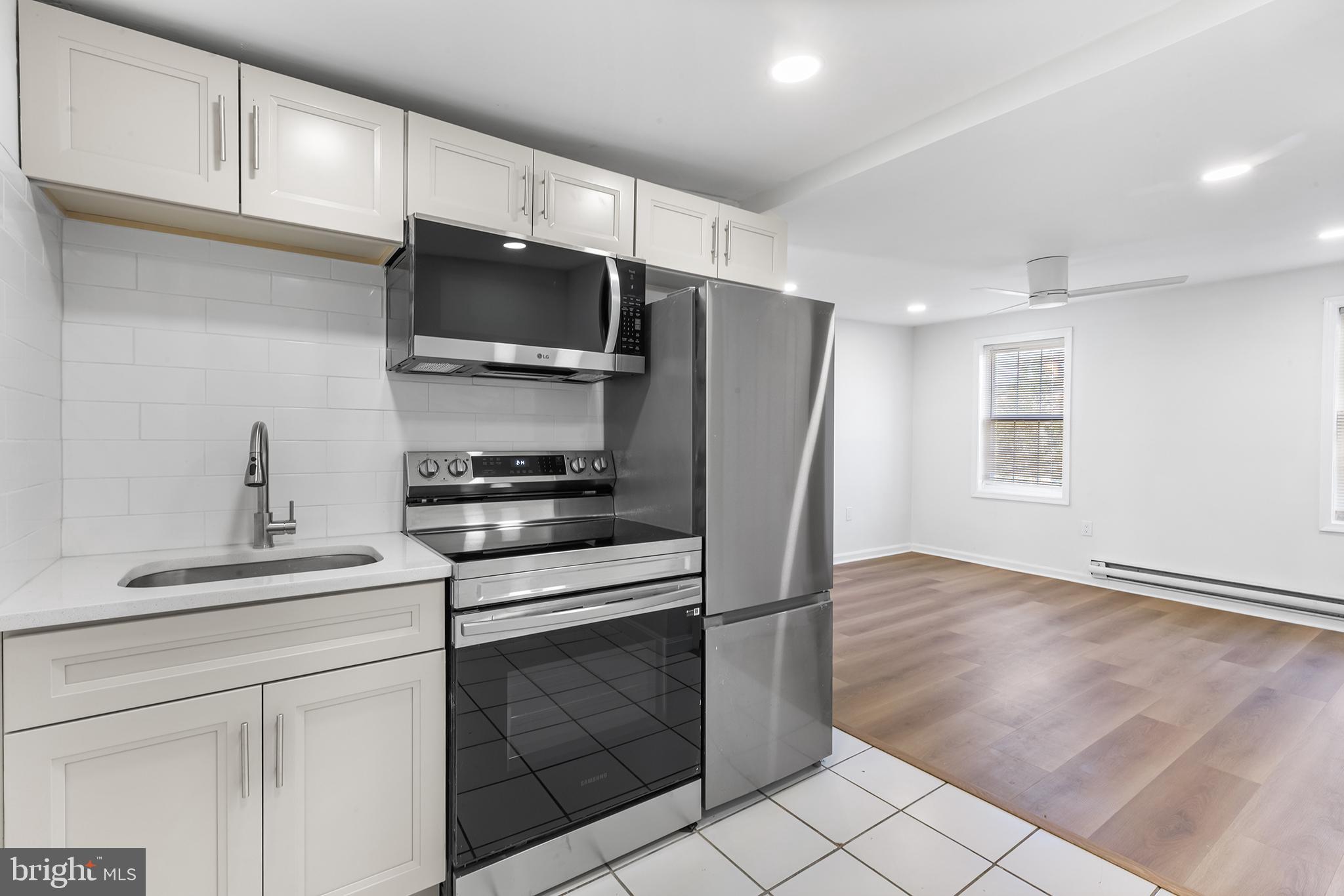 a kitchen with stainless steel appliances white cabinets and a stove top oven