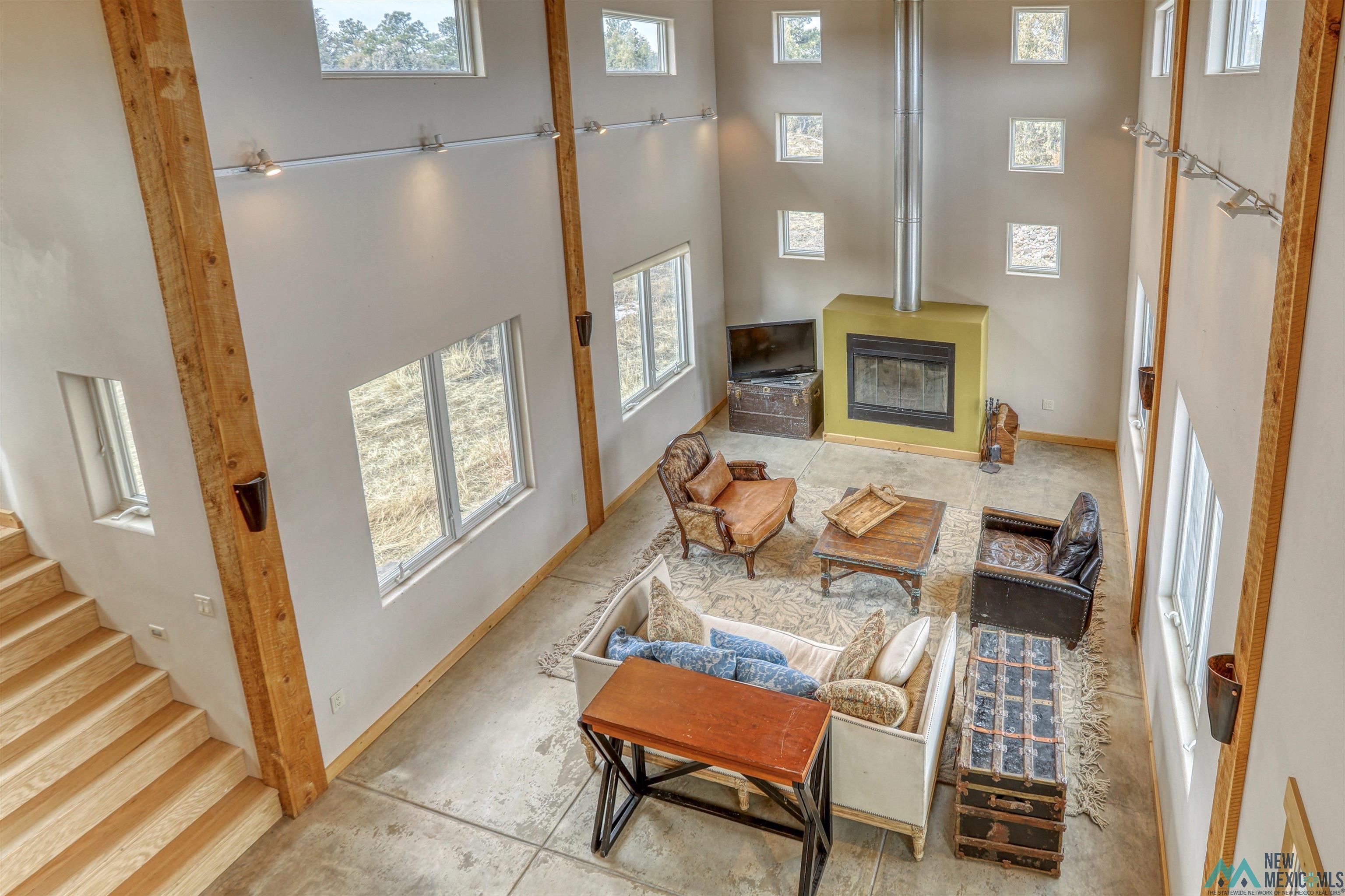 12 Horn Toad Road Chama, NM 87520 - Photo 24 of 52 Living area with a towering ceiling, a wood stove, and stairway