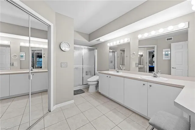 a bathroom with a double vanity sink mirror and toilet