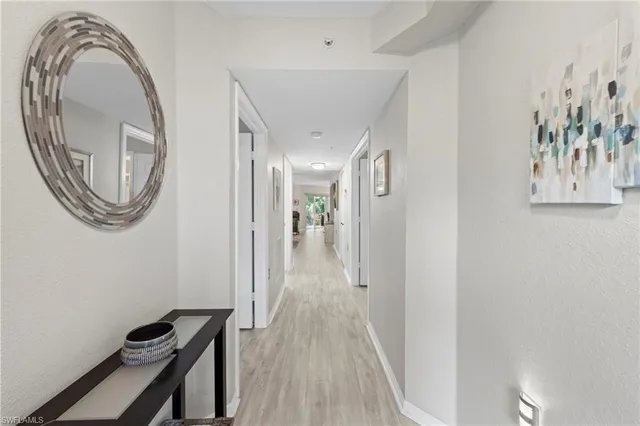 a view of a hallway with entryway wooden floor and a chandelier