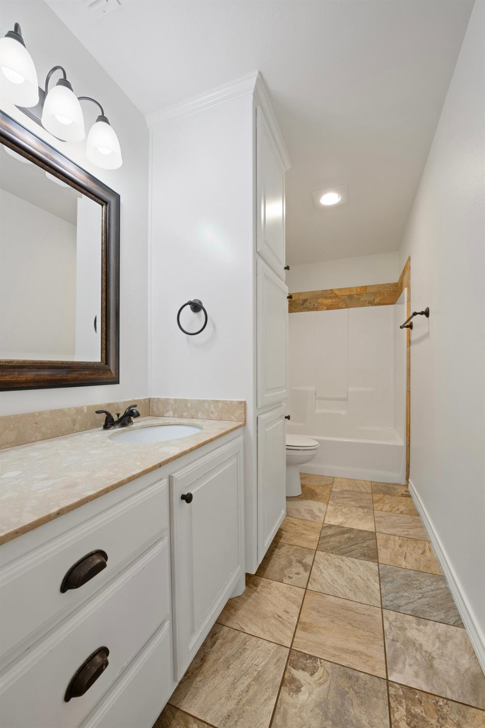 6816 Oakridge Avenue Lubbock, TX 79424 - Photo 11 of 19 a bathroom with a double vanity sink a mirror and a