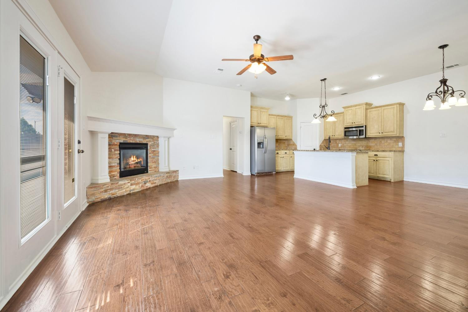 6816 Oakridge Avenue Lubbock, TX 79424 - Photo 2 of 19 a view of a livingroom with a fireplace a ceiling fan and wooden floor