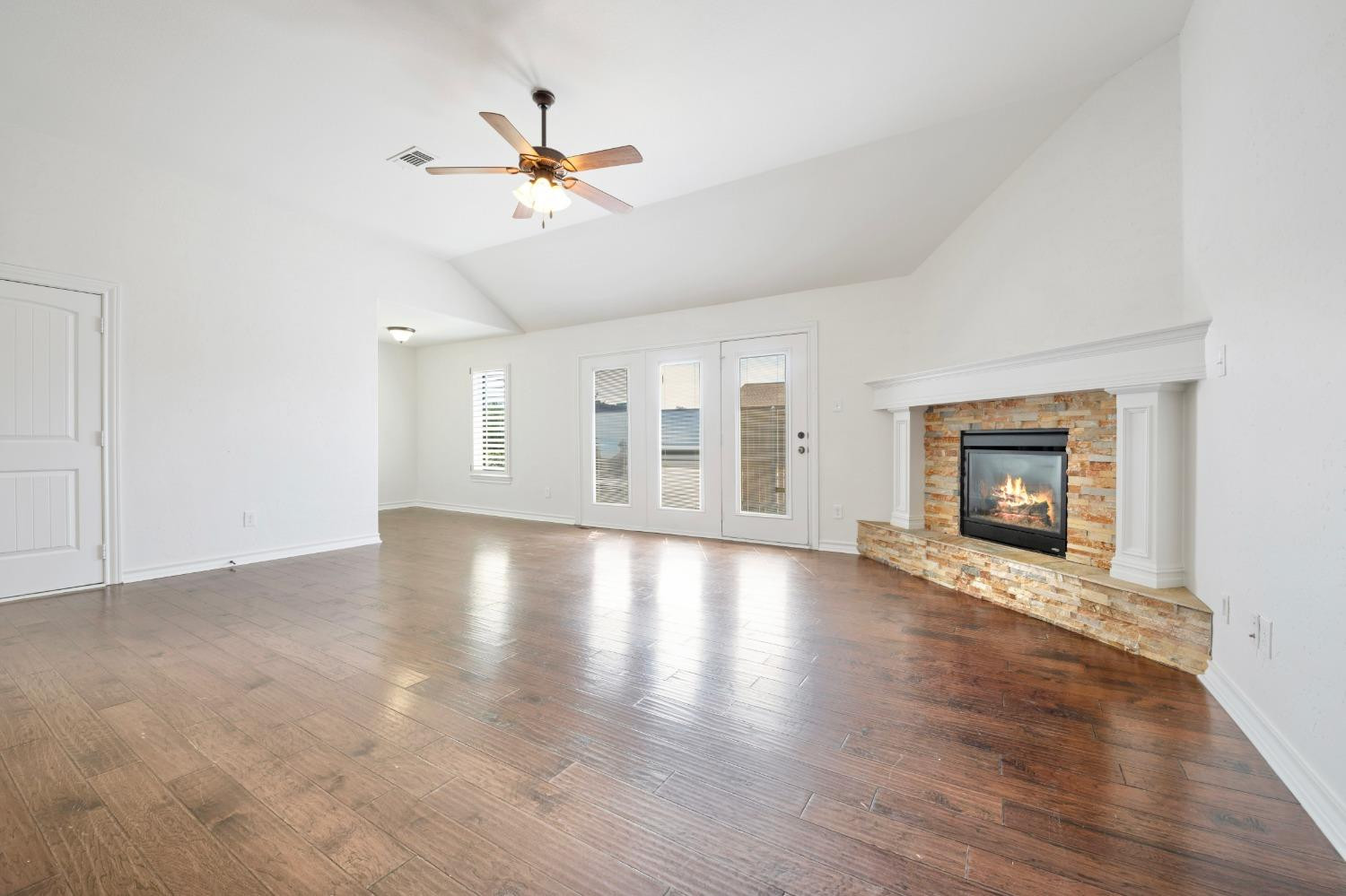 6816 Oakridge Avenue Lubbock, TX 79424 - Photo 3 of 19 a view of an empty room with wooden floor and a window