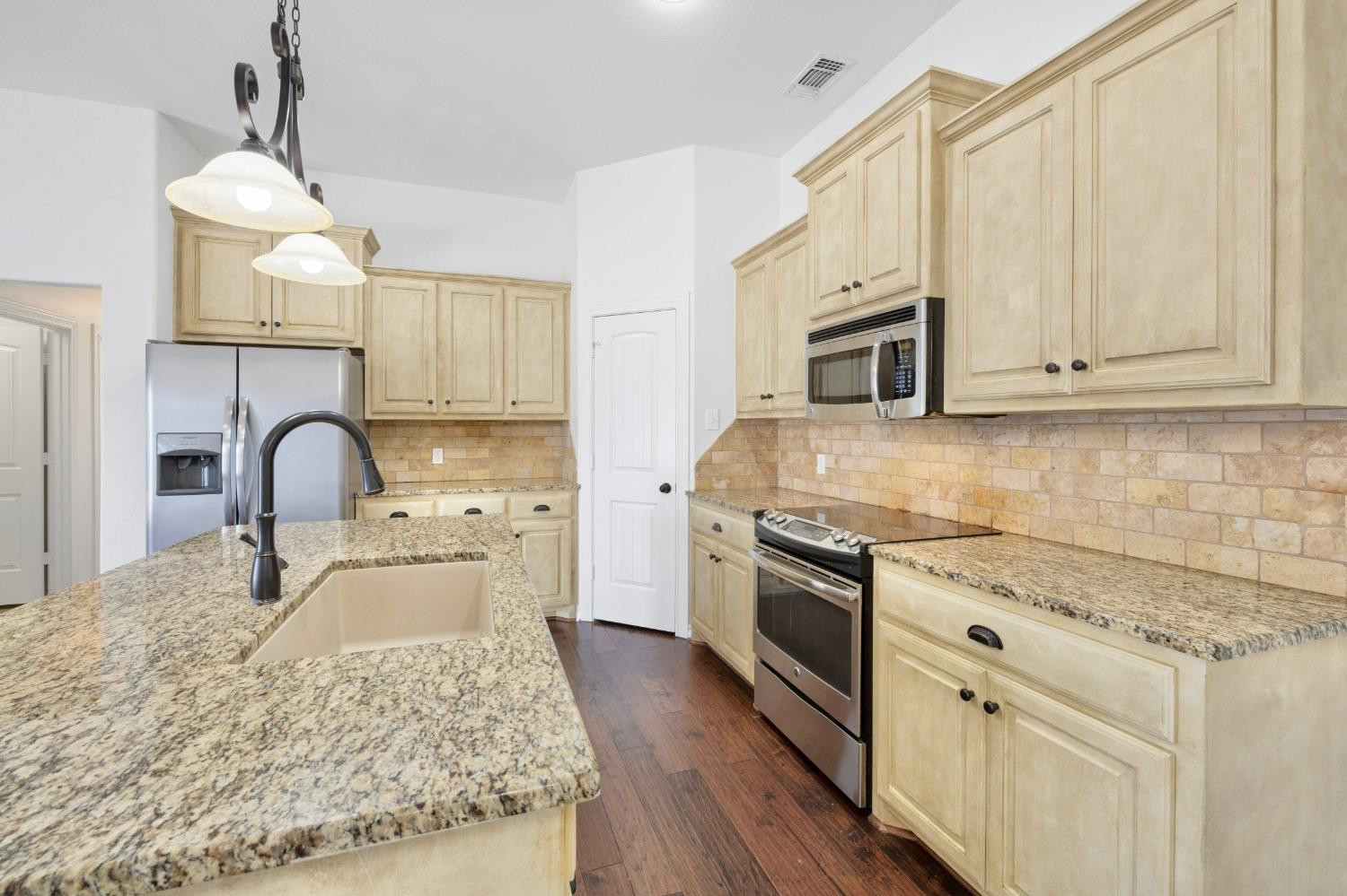 6816 Oakridge Avenue Lubbock, TX 79424 - Photo 4 of 19 a kitchen with stainless steel appliances granite countertop a stove a sink and a microwave