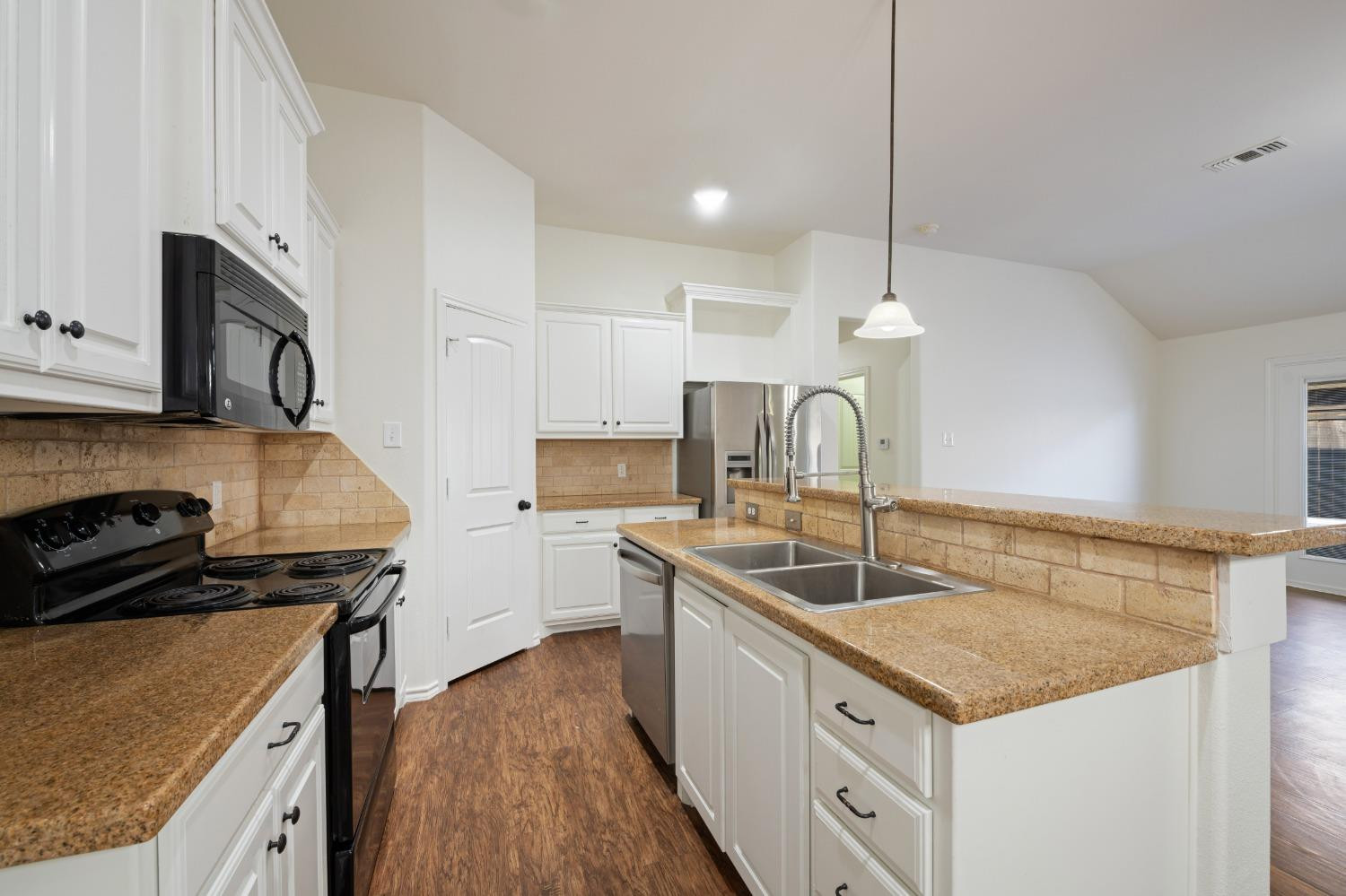 6816 Oakridge Avenue Lubbock, TX 79424 - Photo 5 of 19 a kitchen that has a sink a microwave oven a stove and white cabinets