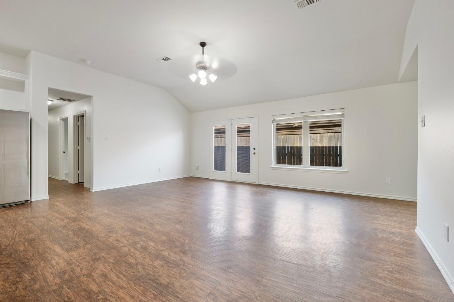 6816 Oakridge Avenue Lubbock, TX 79424 - Photo 7 of 19 a view of an empty room with wooden floor and a window