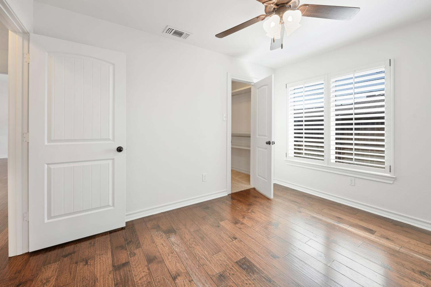 6816 Oakridge Avenue Lubbock, TX 79424 - Photo 9 of 19 a view of an empty room with wooden floor and a window
