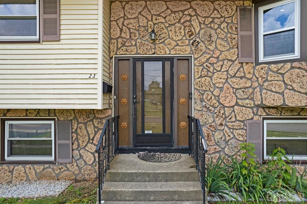 a front view of a house with a tree