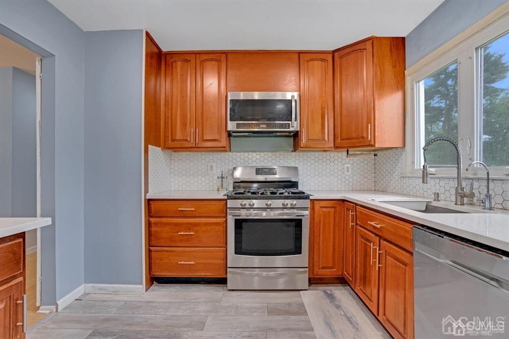 23 Vauxhall Road East Brunswick, NJ 08816 - Photo 6 of 28 a kitchen with stainless steel appliances granite countertop wooden cabinets a stove top oven a sink and dishwasher