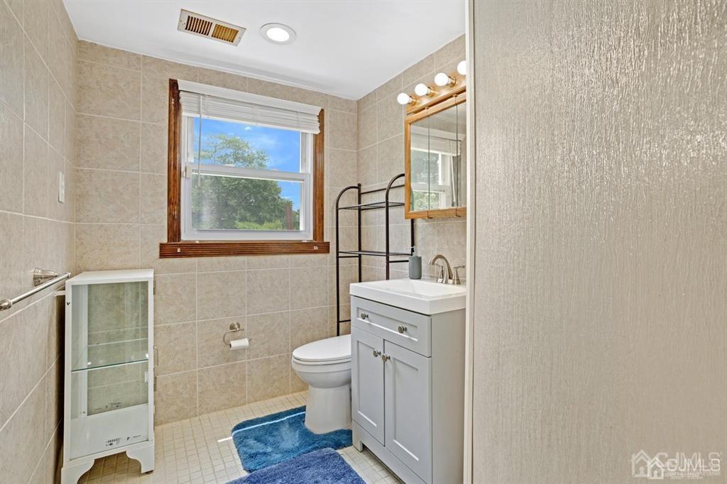 23 Vauxhall Road East Brunswick, NJ 08816 - Photo 9 of 28 a bathroom with a toilet sink and mirror