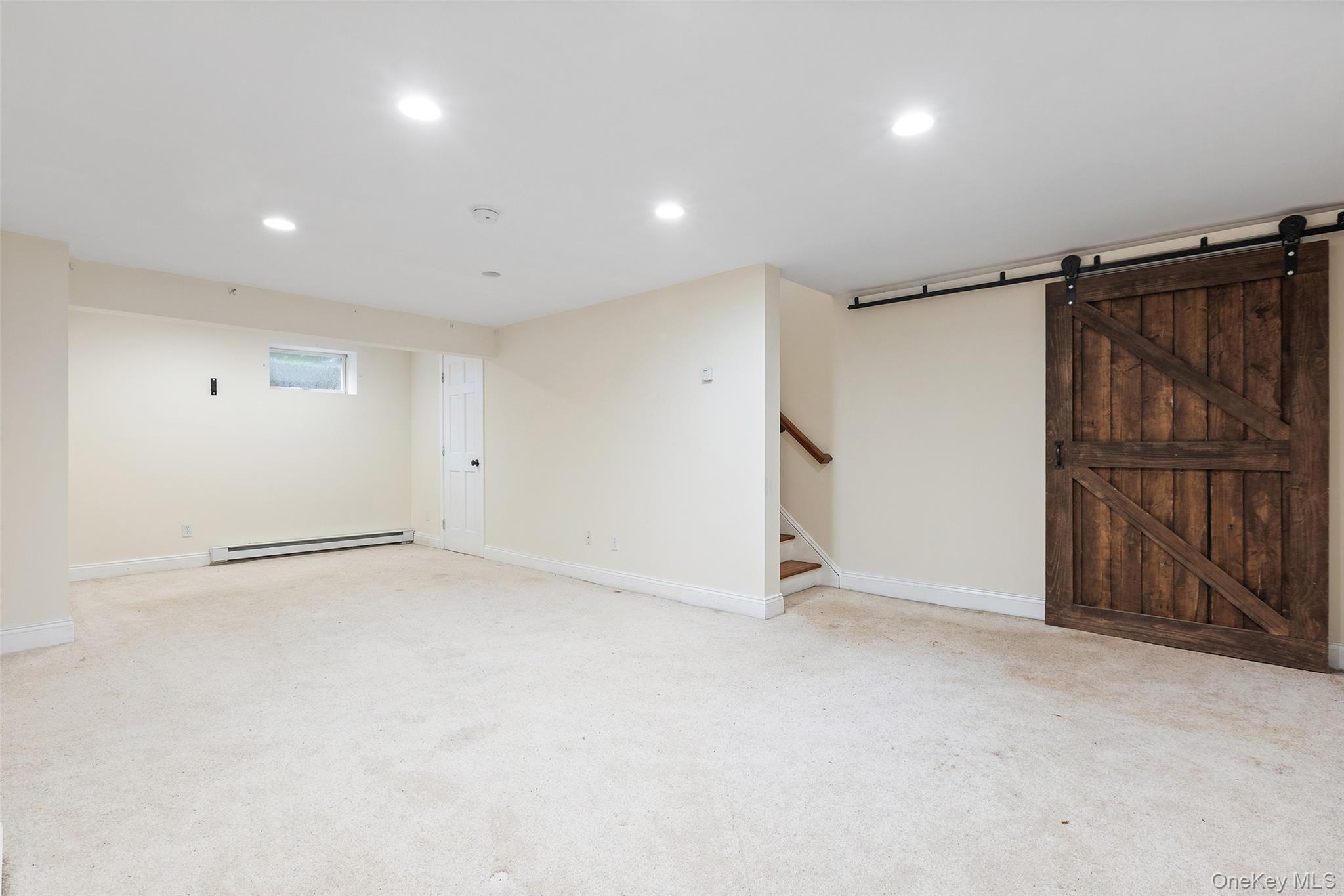 56 Huntville Road Katonah, NY 10536 - Photo 31 of 44 Lower Level Rec room with door to utility room with workbench, utilities and storage.