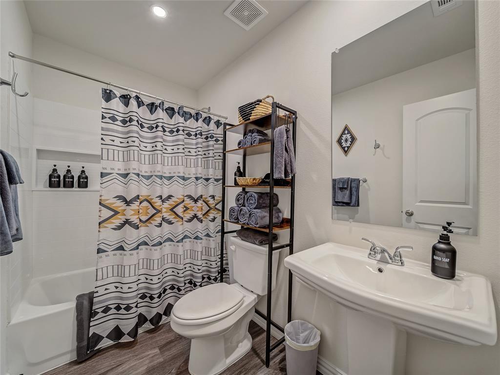 921 West 9th Street Bonham, TX 75418 - Photo 13 of 22 2nd Full Bathroom featuring shower / bath combo and dark wood finished floors