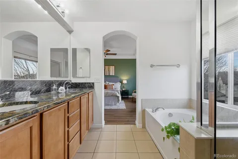 a large bed sitting in a bedroom next to a flat tv screen tv and a mirror