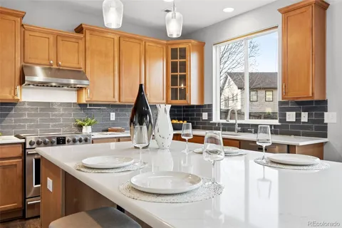 a kitchen with stainless steel appliances wooden cabinets a sink and a large window