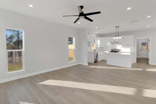 a view of a kitchen with a sink hardwood floor and a window