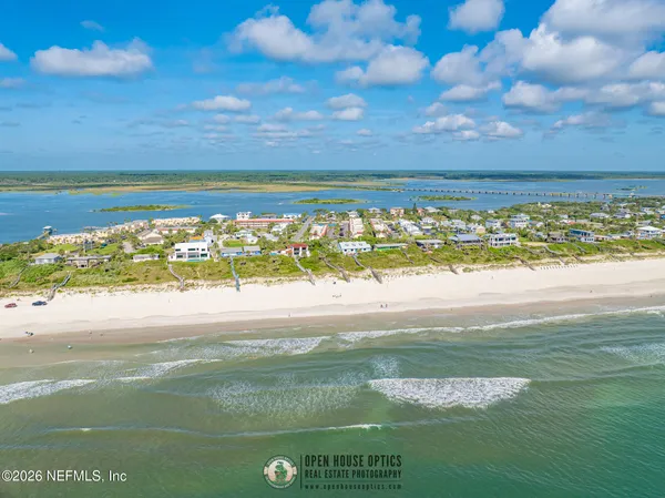 an aerial view of residential houses with outdoor space and ocean view