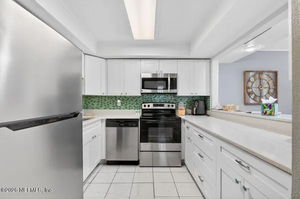 a kitchen with stainless steel appliances white cabinets and a stove a oven
