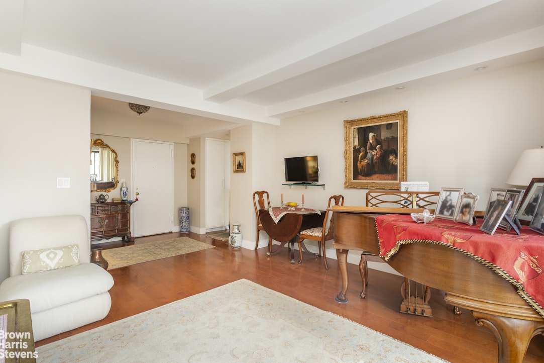 750 Park Avenue, Unit 12B Manhattan, NY 10021 - Photo 3 of 10 a living room with furniture a air conditioner vent and a window