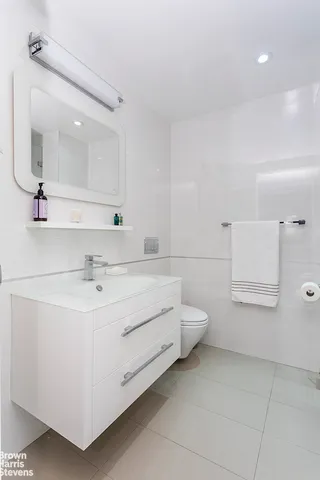 a bathroom with a sink a toilet and mirror