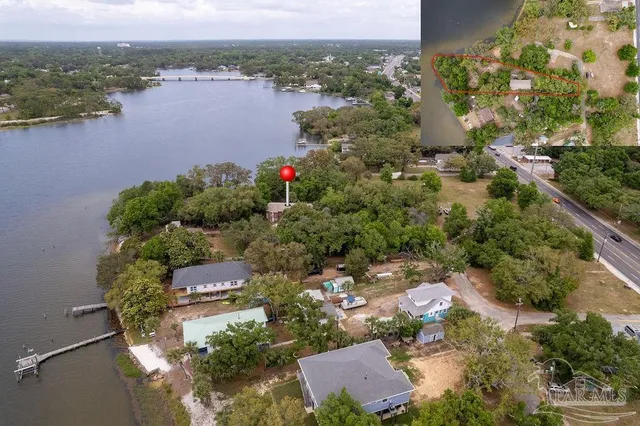 an aerial view of residential house with outdoor space and trees all around
