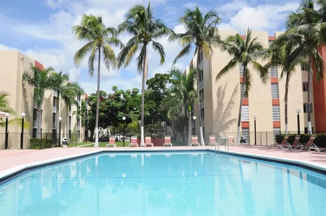 a view of swimming pool with palm trees