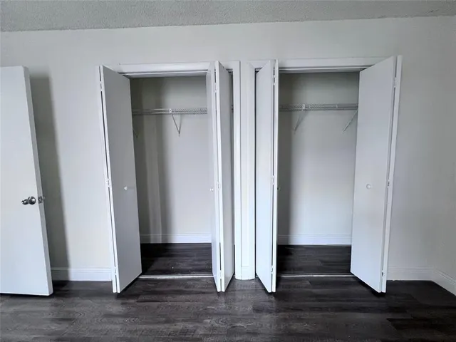 an empty room with wooden floor and closet