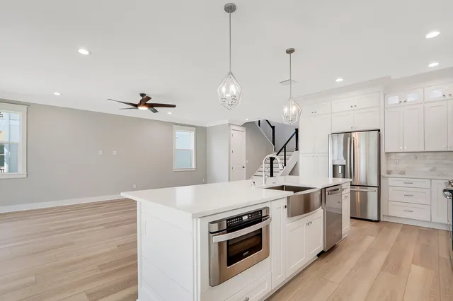 a kitchen with granite countertop white cabinets and white appliances