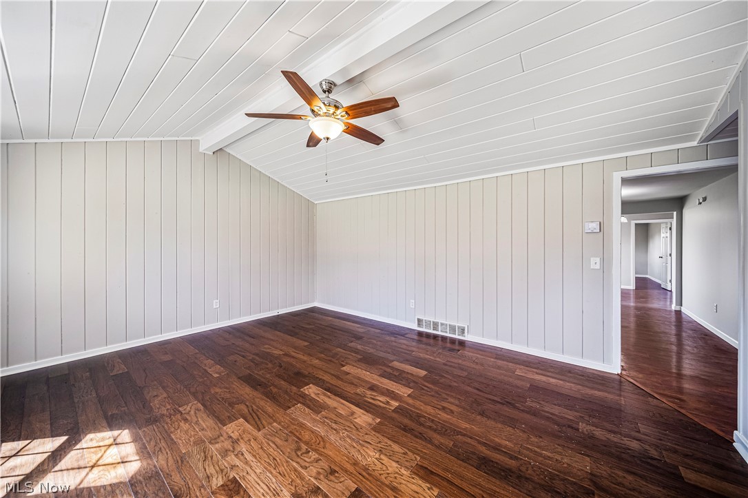 3395 Maple Road Jefferson, OH 44047 - Photo 20 of 36 Unfurnished room featuring ceiling fan, dark hardwood / wood-style flooring, and lofted ceiling with beams