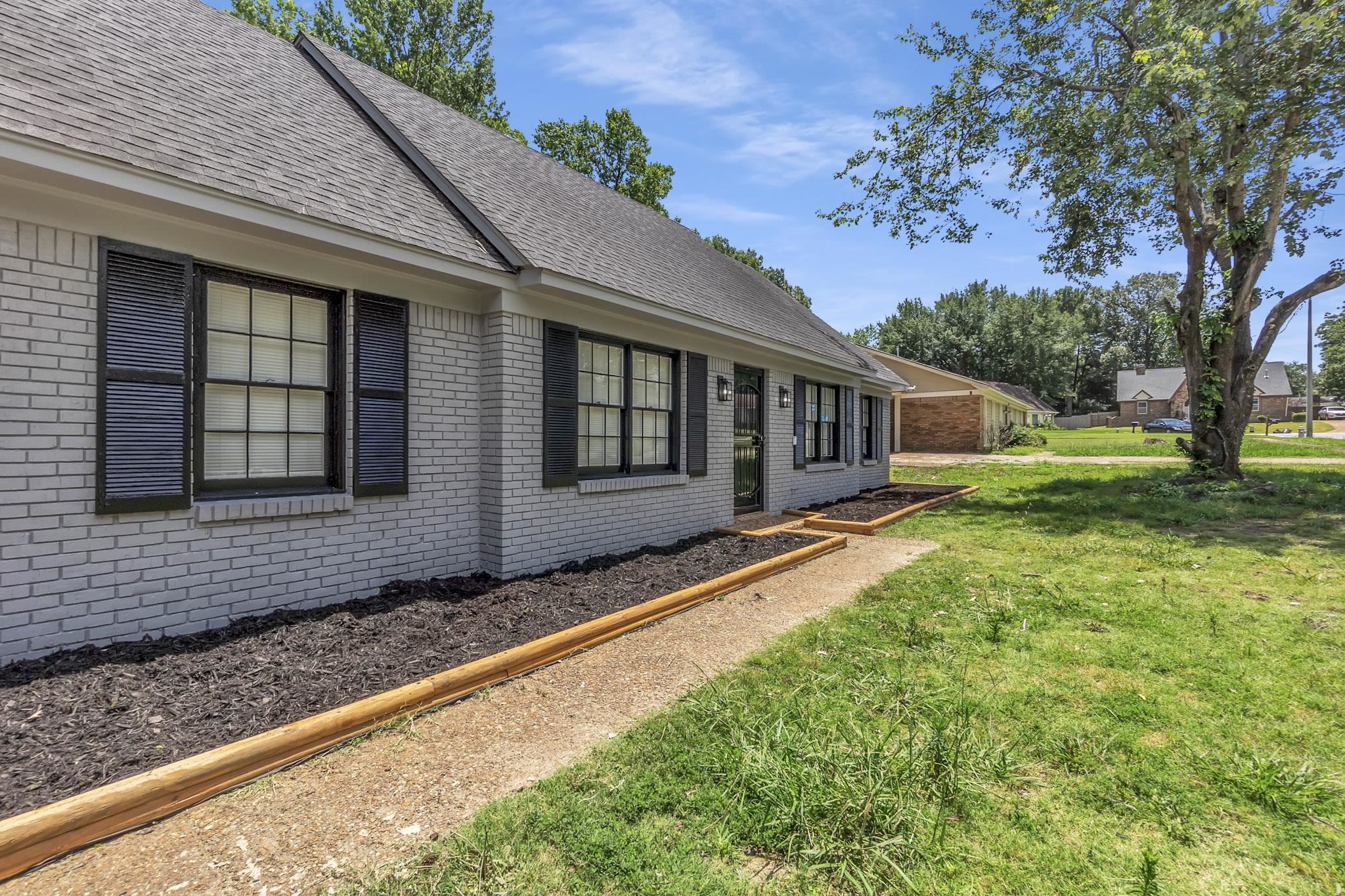 3314 Bright Ridge Cove Memphis, TN 38115 - Photo 2 of 16 Brick exterior with a gray painted finish, dark shutters, and a gray shingle roof