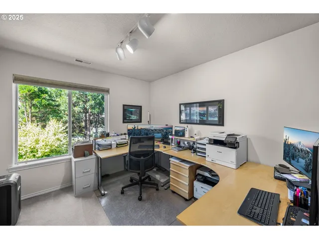 a workspace with furniture and a large window