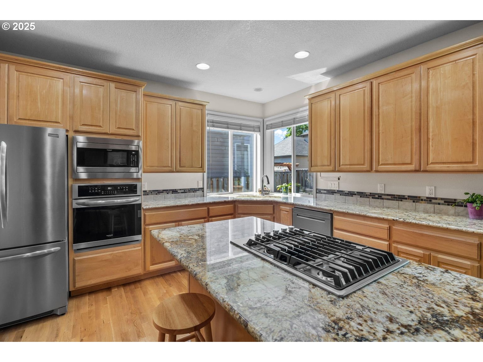 14941 Northwest Wendy Lane Portland, OR 97229 - Photo 6 of 26 a kitchen with granite countertop a stove a sink and a refrigerator
