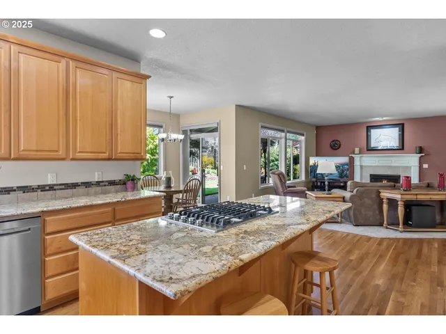 a kitchen with kitchen island granite countertop a sink stove and cabinets
