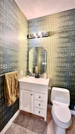 a bathroom with a toilet sink and mirror