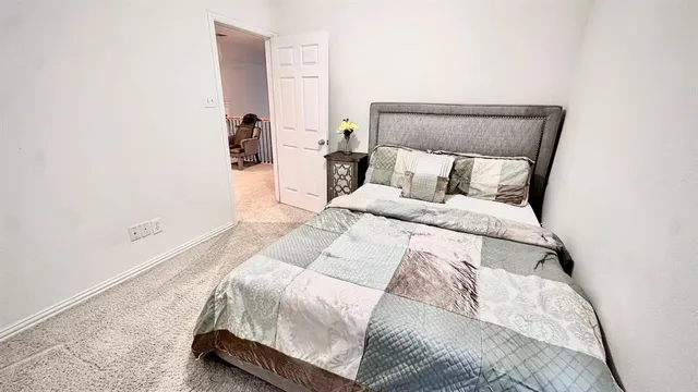 a large bed sitting in a bedroom next to a lamp