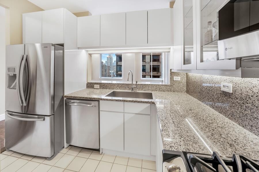 200 Riverside Boulevard, Unit 15E Manhattan, NY 10069 - Photo 5 of 15 a kitchen with stainless steel appliances granite countertop a refrigerator a stove and a sink with granite countertops