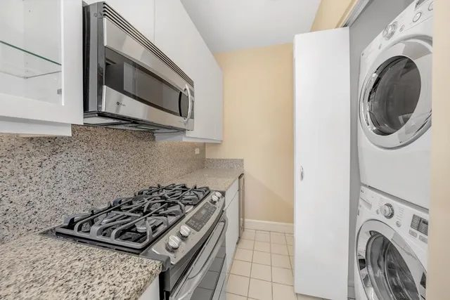 a kitchen with stainless steel appliances granite countertop a refrigerator a stove and a sink with granite countertops