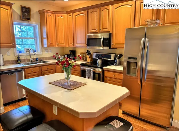 a kitchen with a refrigerator a stove a sink dishwasher and wooden cabinets