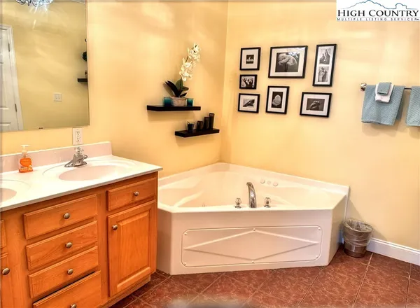 a spacious bathroom with a tub sink and mirror
