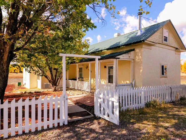 a view of a house with a small yard and wooden fence