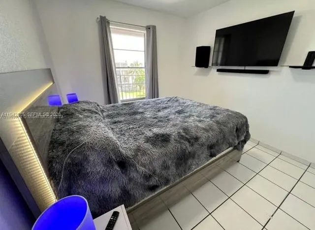 a bedroom with a bed and flat screen tv