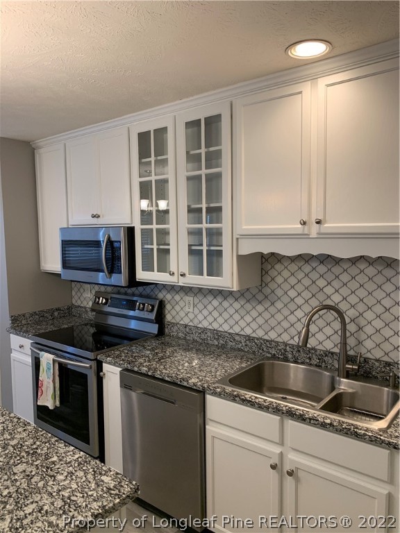 5428 Arnette Road Hope Mills, NC 28348 - Photo 25 of 41 a kitchen with stainless steel appliances granite countertop a sink stove and cabinets
